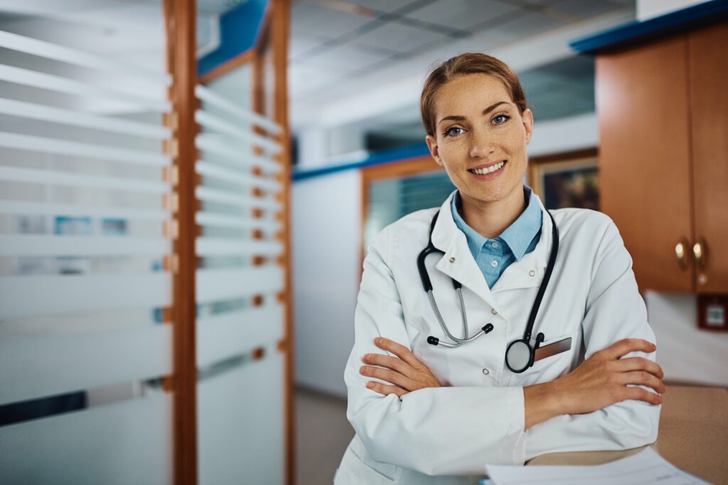 Confident female doctor at medical clinic looking at camera.