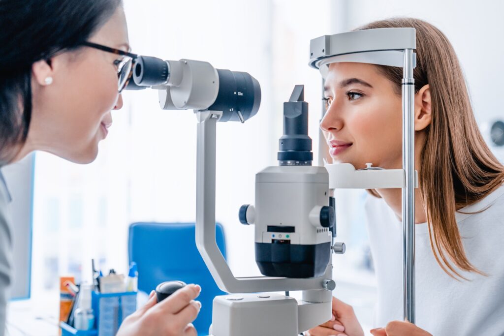 Side view shot of female doctor and patient in ophthalmology clinic