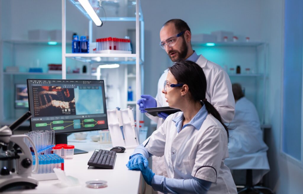 Woman scientist and man doctor studying virus expertise in medicine lab