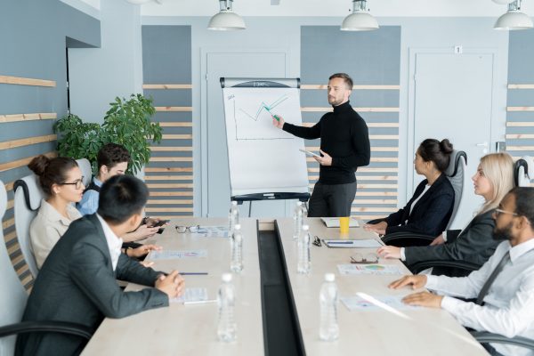 Confident analyst presenting graph at staff meeting